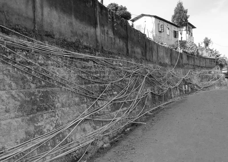 Water cables pinned to side walls along a street in Kohima, Nagaland